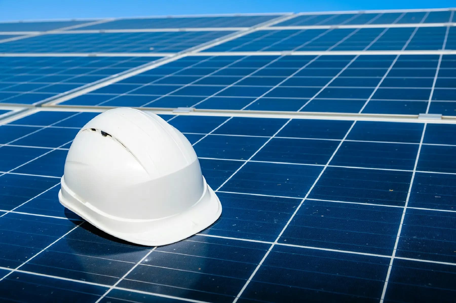 Safety helmet resting on solar panels at a renewable energy site